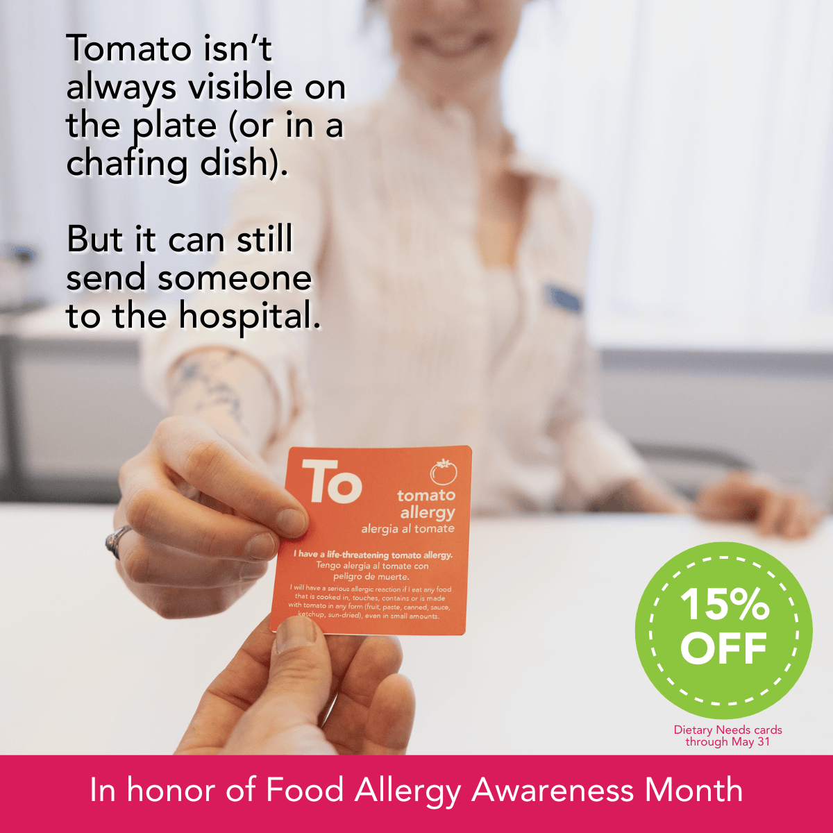 A smiling woman in a light blouse hands a red dietary needs card across a white counter to an unseen attendee. The card reads "To – Tomato Allergy" in bold white text and includes a bilingual warning about life-threatening tomato allergies. The focus is on the card, emphasizing its clarity and importance in communicating dietary needs during events.