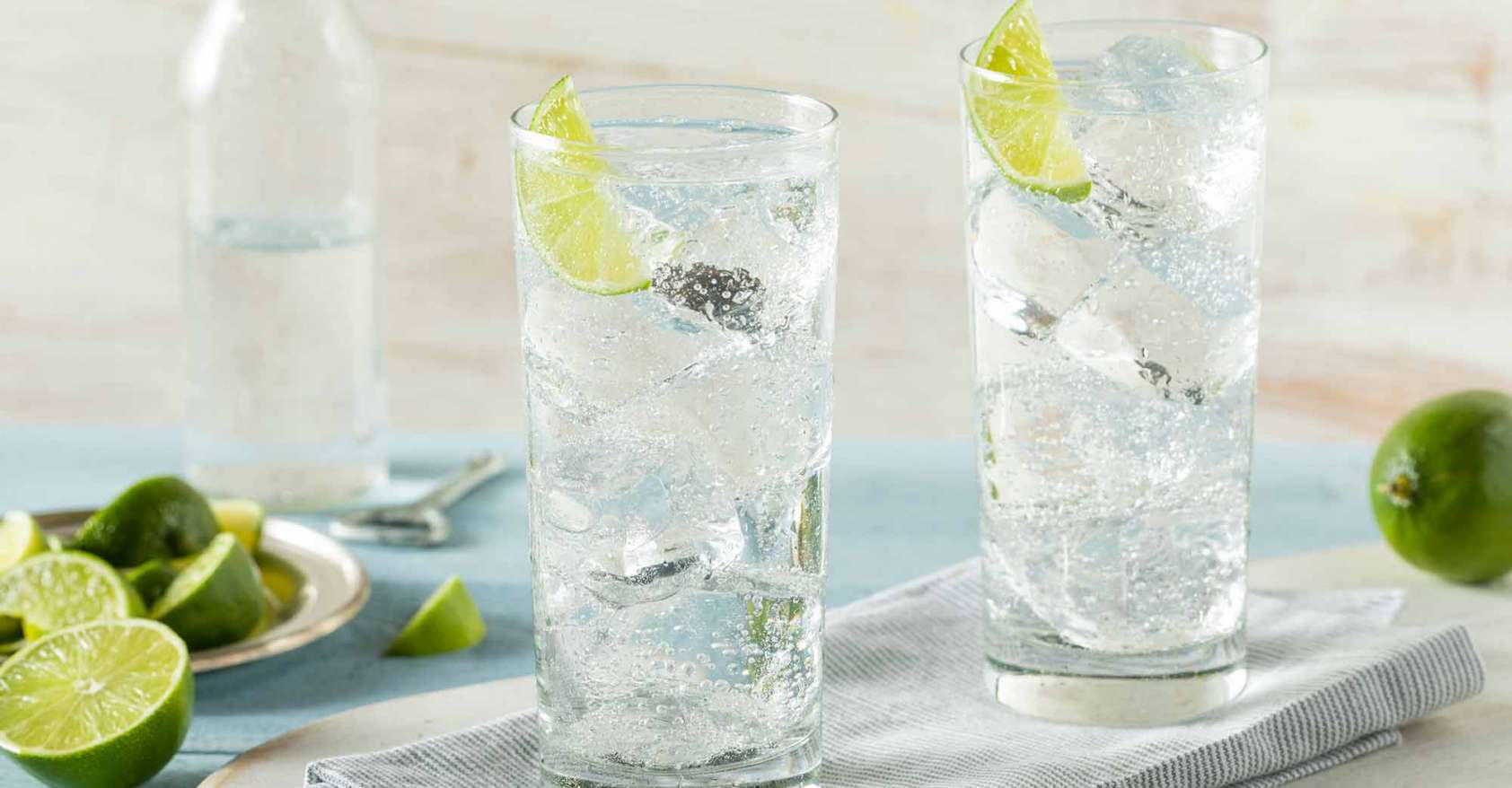 Two clear glasses of Hard Sparkling Water with limes on a tray Drynuary