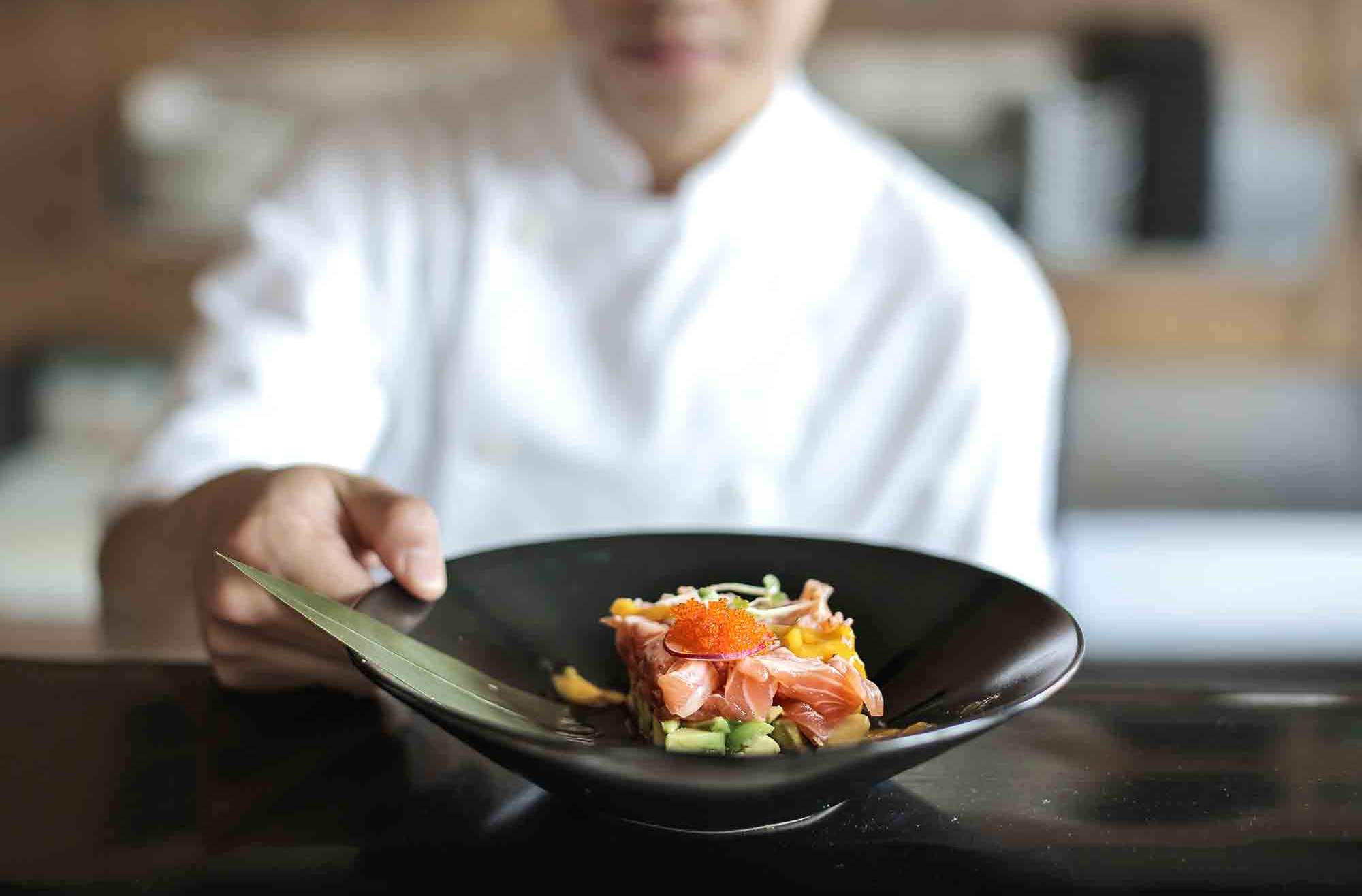 Chef showing plate with fish tartare coronavirus