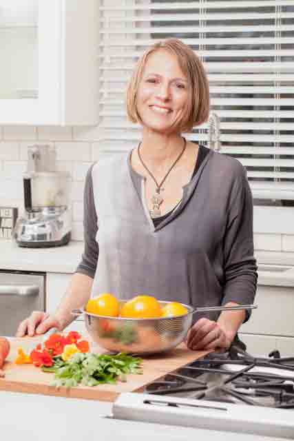 Stefanie Sacks standing in kitchen with a bowl fruit in front of her heart-healthy