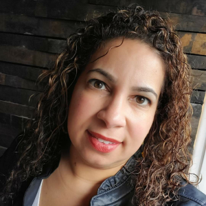 close up of smiling woman with long brown curly hair wearing a denim top Heart health Jenn Sena