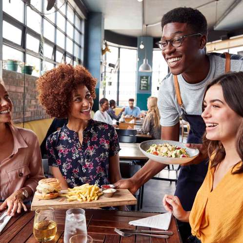 Waiter Serving Group Of Female Friends Meeting For Drinks And Food In Restaurant food allergy safety