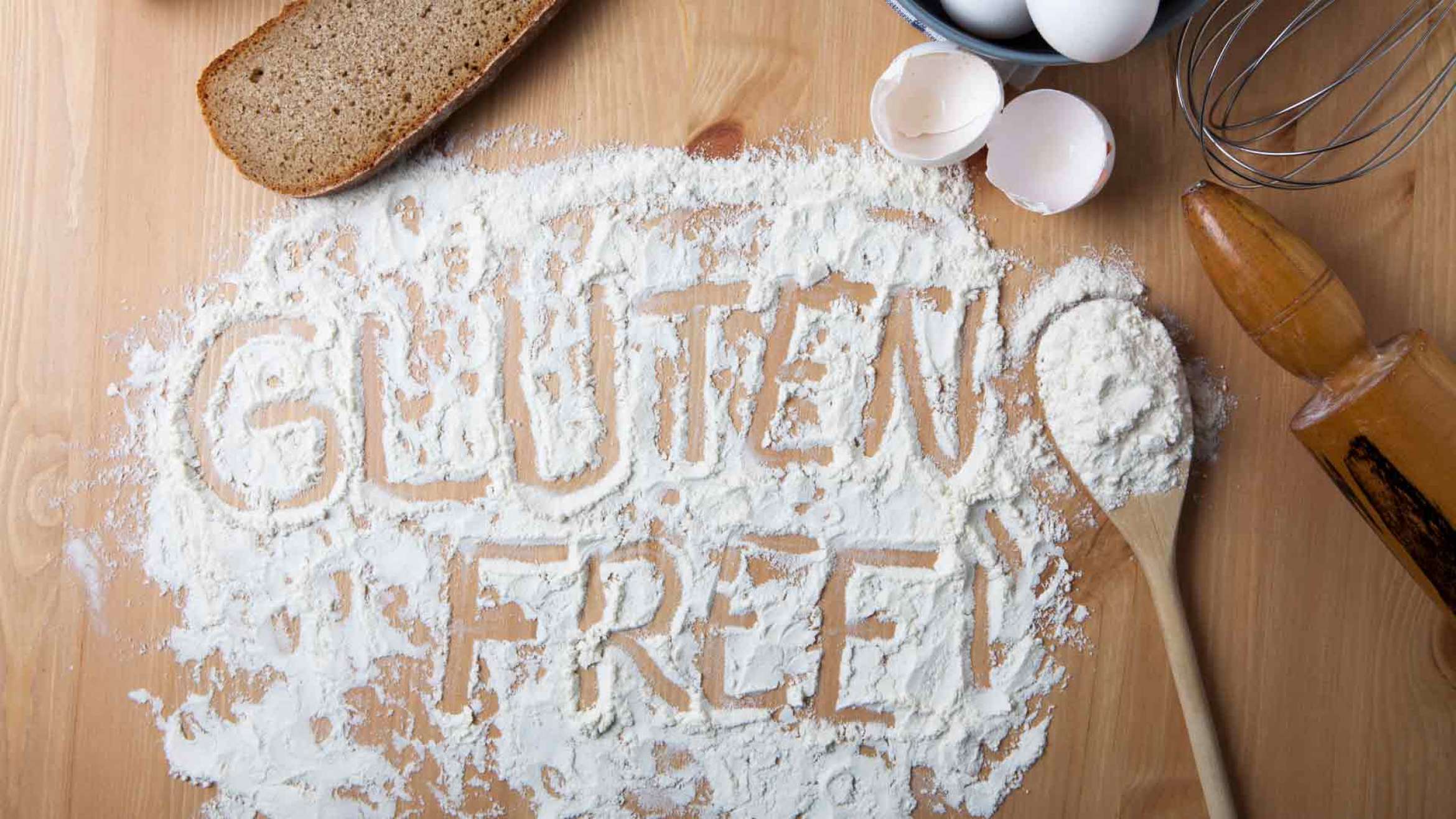 The words Gluten Free written in flour on a wooden table Gluten-free Watchdog