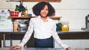 picture of woman standing behind a table with her hands on the table Keitra Bates of Marddy's promoting Financial Independence