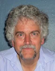 Man with black & gray goatee and hair staring straight at the camera. He was saved by eating a Whole Food Plant-based Diet & Fighting Hunger