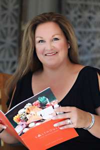 Smiling woman holding a cookbook in her hands