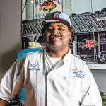 Chef Keith Rhodes of Catch Restaurant in his chef's coat and baseball hat