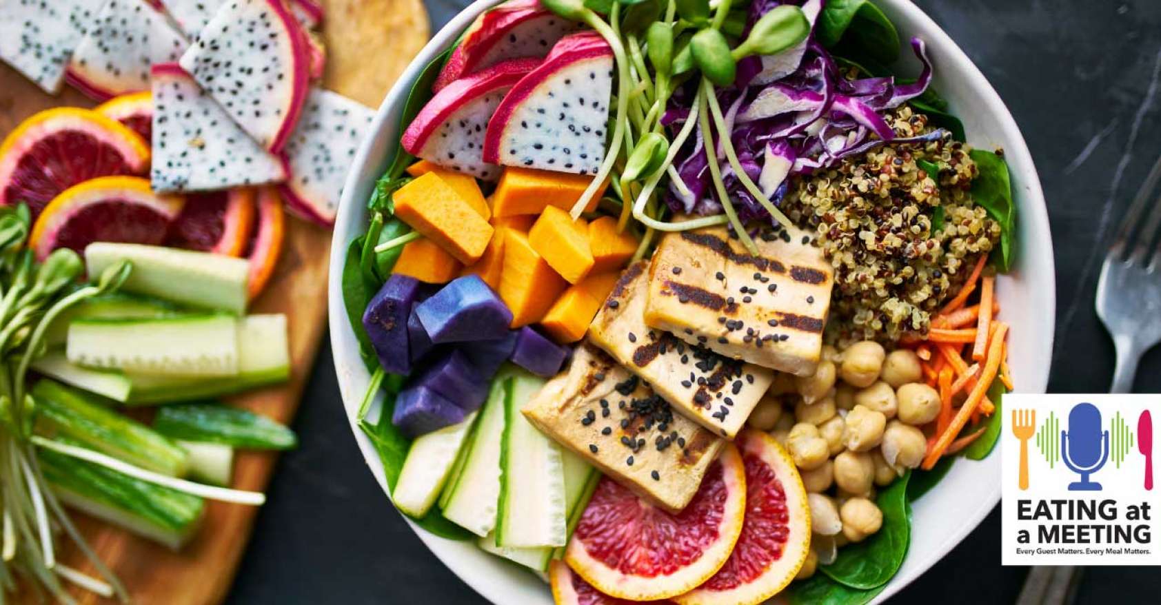 Looking down on a bowl of plant-based food with vegan sides on a wooden board