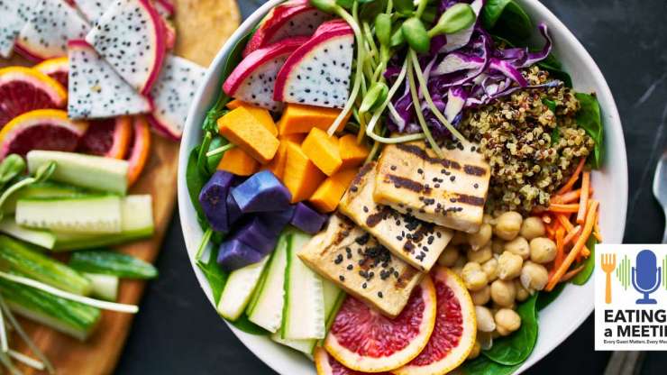 Looking down on a bowl of plant-based food with vegan sides on a wooden board