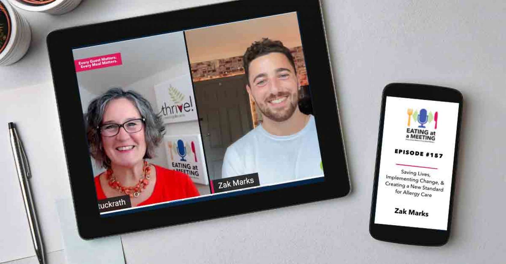 An iPad and iPhone on a table. On the iPad is a picture of two men who are on video screen. On the iPhone is the Eating at a Meeting podcast logo with Episode #157 Saving Lives, Implementing Change, & Creating a New Standard for Allergy Care with Zak Marks