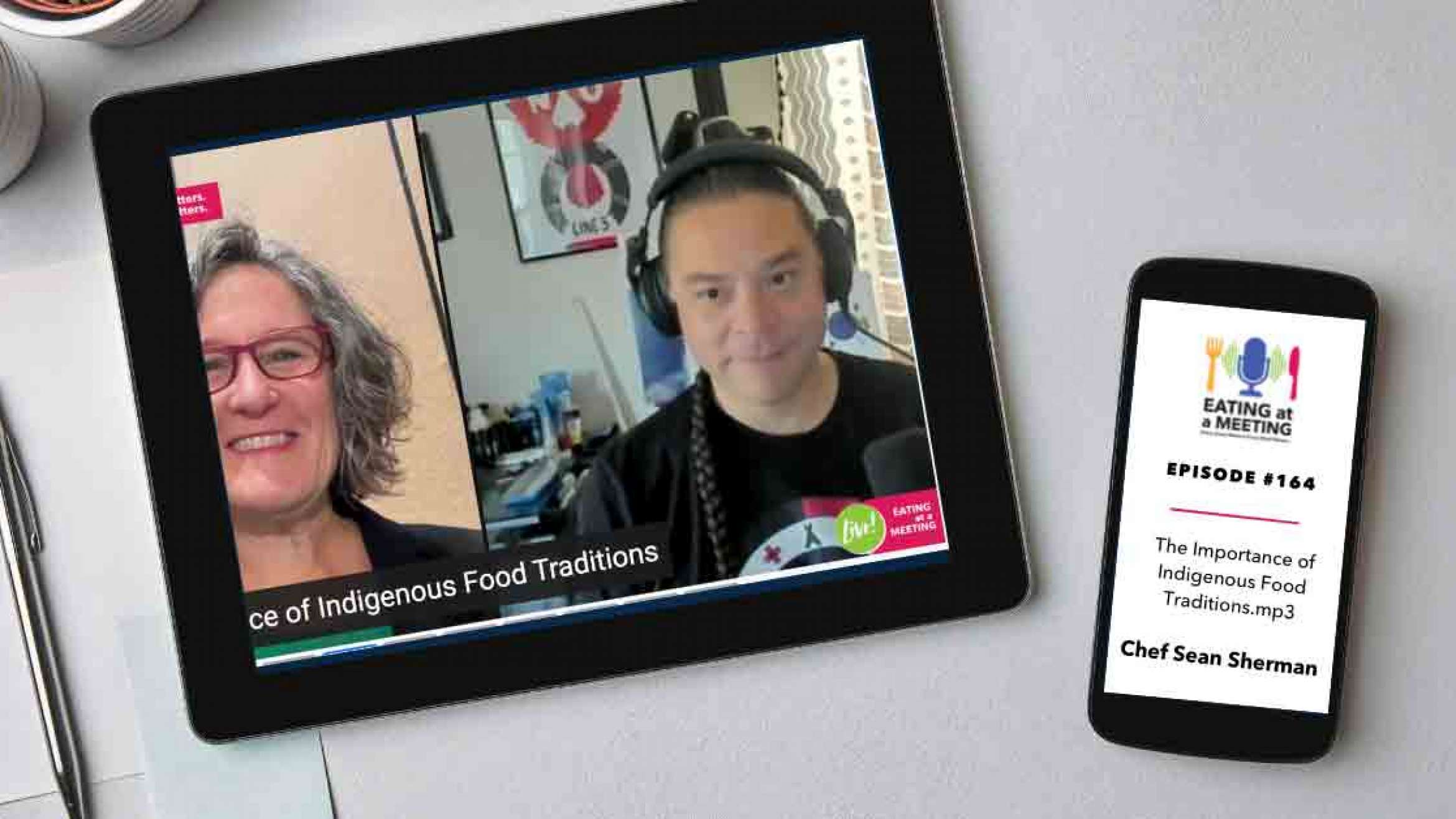 An iPad and iPhone on a table. On the iPad is a picture of two men who are on video screen. On the iPhone is the Eating at a Meeting podcast logo with Episode #163 The Importance of Indigenous Food Traditions with Chef Sean Sherman, The Sioux Chef