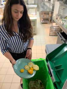 Woman throwing food into a food waste bin for composting