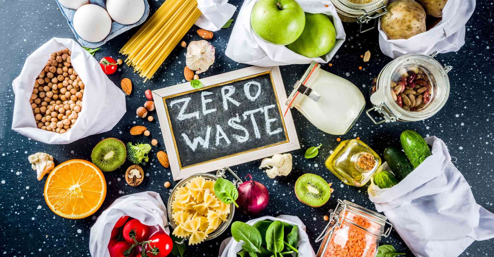 camera looking down on bags of food on a table with the words zero waste on a chalkboard in the center