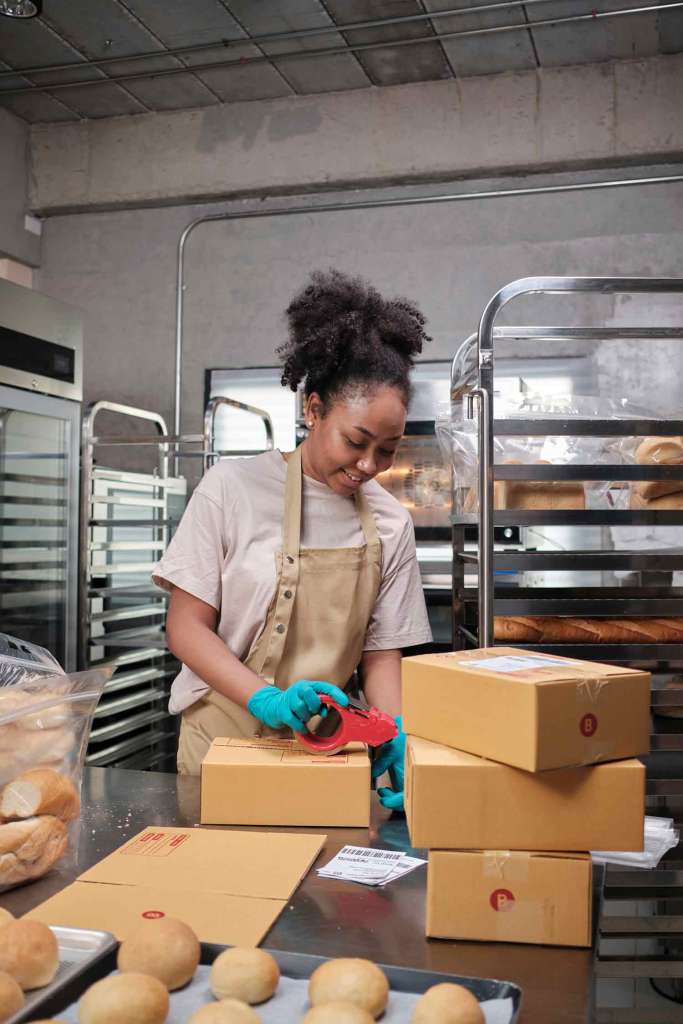 Female-cook-is-packing-handmade-and-fresh-baked-bread following food safety practices