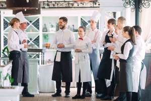 Restaurant manager and his staff in terrace. interacting to head chef in restaurant